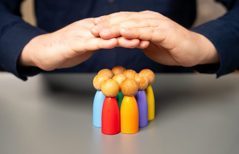 hands-protecting-wooden-figures-representing-a-tea-